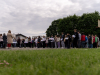 Na sliki je večja skupina otrok, mladostnikov in odraslih, zbranih na šolskem igrišču, ob začetku organiziranega dogodka-mednarodnega športno družabnega srečanja.